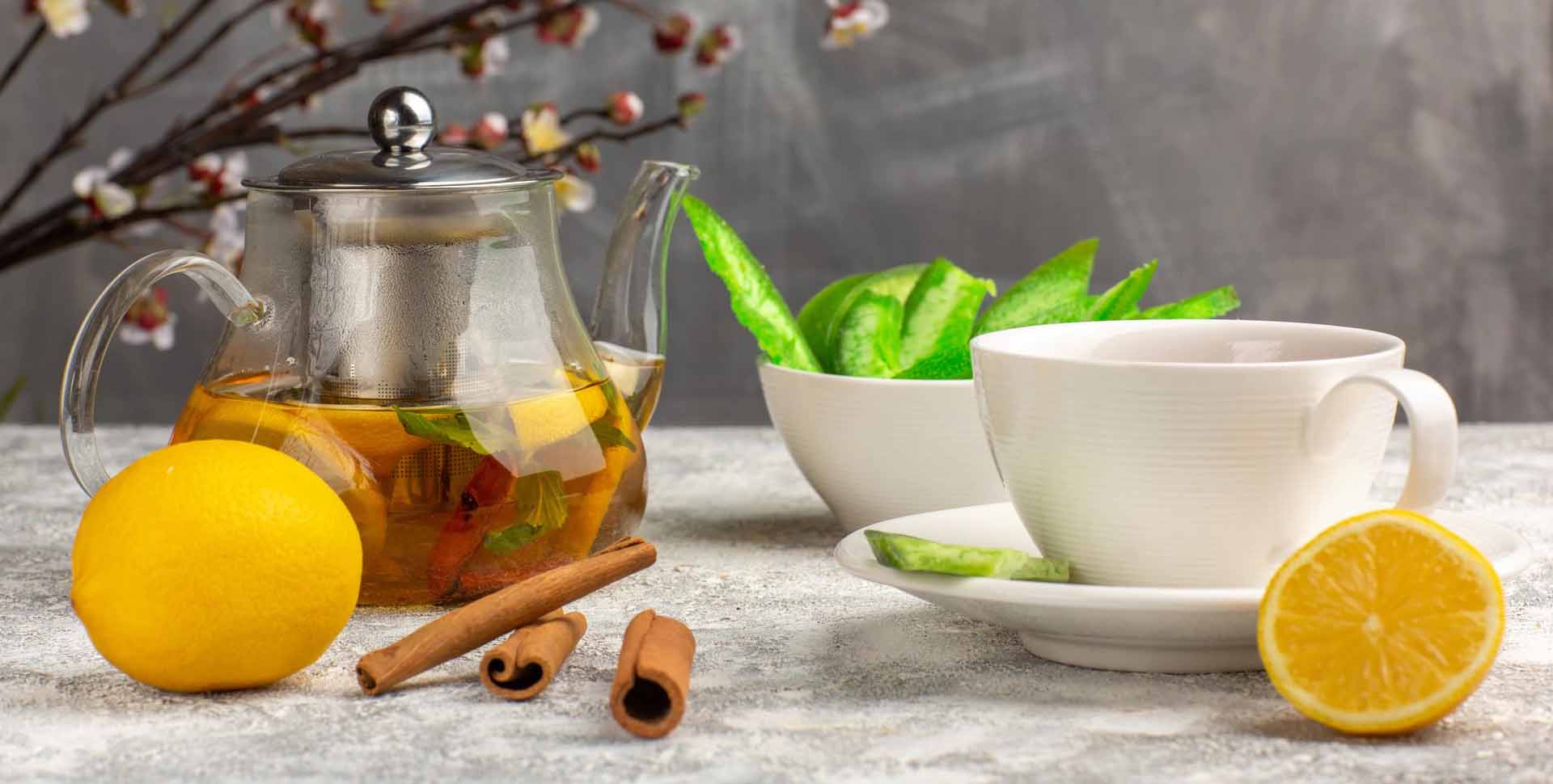 Orientálne doplnky - konvica s čajom, čajové šálky, škorica a citrón na štylizovanom pozadí